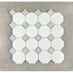 a white tile with blue and gray flowers on the edges, in an irregular pattern