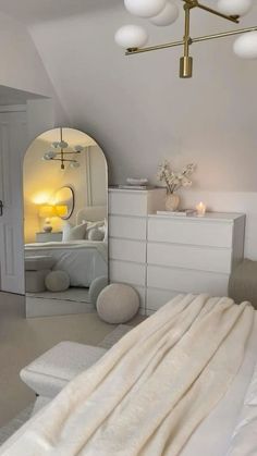 a bedroom with white furniture and lots of lights on the ceiling, along with an arched window