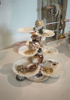 a stack of seashells sitting on top of a white table next to a mirror