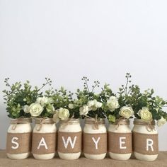 four mason jars with flowers in them sitting on a table next to the word saver