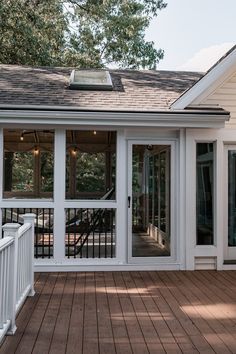 a white house with wooden decking and sliding glass doors