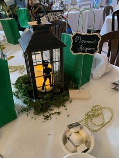 a small lantern is on the table with some candles and other items around it,