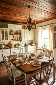 a dining room table and chairs with plates on it