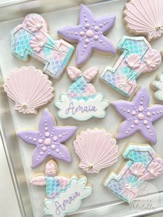 decorated cookies in the shape of mermaids and seashells with names on them