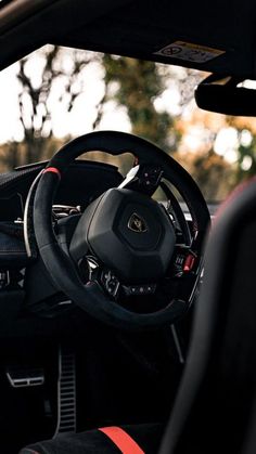 the interior of a sports car with red and black trim