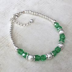 "THE DETAILS This bracelet features the August birthstone color of Peridot. The Peridot-colored glass beads have a faceted cut to reflect the light; the bracelet is also highlighted with silver shimmer stardust beads! These bracelets make wonderful gifts! ** PLEASE NOTE ** This item is not made of gemstone beads. The colored glass beads in the bracelet and earrings are meant to represent the birthstone color! ORDER OPTIONS When ordering, please use the \"Product Options\" menu to indicate if you Faceted Beads Bracelet For May Birthstone Gift, Faceted Beads Bracelets As May Birthstone Gift, May Birthstone Bracelets With Faceted Beads As Gift, May Birthstone Faceted Beads Bracelet, Green Crystal Jubilee Bracelet Gift, Faceted Round Bead Bracelets For May Birthstone, Faceted Round Beads Bracelet For May Birthstone, Adjustable Green Birthstone Jewelry, Green Adjustable Birthstone Jewelry