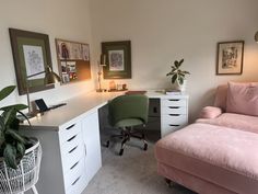 a pink couch sitting next to a white desk