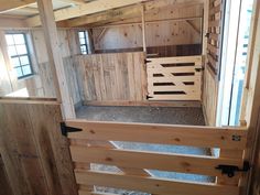 the inside of a barn with wooden walls and doors on each side, looking down