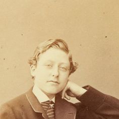 an old black and white photo of a man in a suit with his hand on his ear