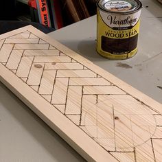 a can of varnish wood sitting next to a piece of wood that has been cut in half