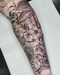 a woman's arm with flowers and birds on it