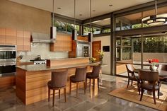 a modern kitchen with wooden cabinets and stainless steel appliances is pictured in this image from the dining room