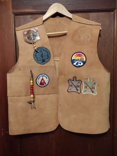 a leather vest with patches and buttons on it