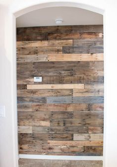 a bathroom with wood planks on the wall