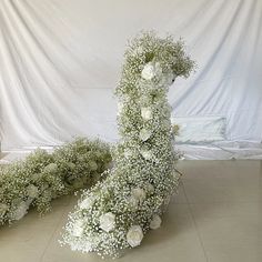 flowers are arranged on the floor in front of a white backdrop