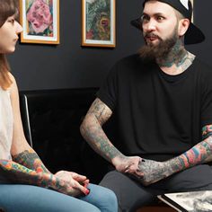 two tattooed men sitting next to each other