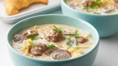 two bowls of soup with meatballs and cheese