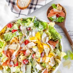 a salad in a bowl with bread on the side