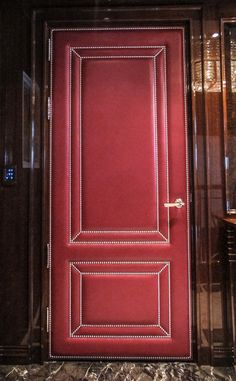 a red door in a room with marble flooring