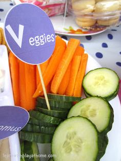 a plate with cucumbers, carrots and pickles on it that says veggies