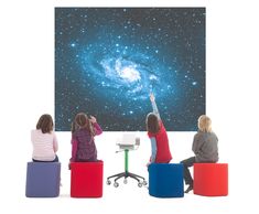 three children sitting on stools in front of a projector screen and looking at the stars