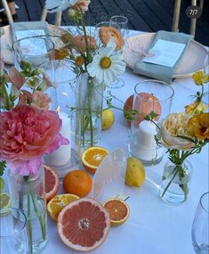 the table is set with flowers, oranges and lemons for an elegant dinner