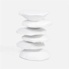 a stack of white plates sitting on top of each other in front of a white background