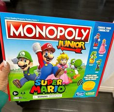 someone is holding up a monopoly junior game