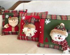 three christmas pillows with snowmen and santa hats on them