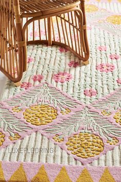 a wicker chair sitting on top of a rug next to a wooden rocking chair