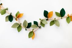 some green leaves and beads are hanging on the wall