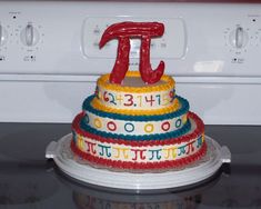 a cake with the letter t on it sitting in front of a stove top oven