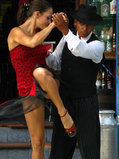 a man and woman dancing on the street