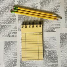 two yellow pencils sitting on top of a piece of paper next to each other