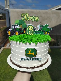 there is a birthday cake that looks like a john deere tractor on the grass