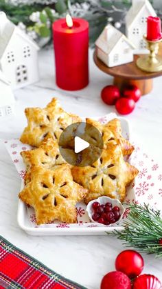 a white plate topped with pies and cranberries next to christmas decorations on a table