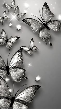 several butterflies flying in the air with sparkles on their wings, and one is black and white