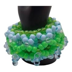 Blue and green are the star colors of this Shaker Kandi 3d cuff.  There are 10 mini blue pacifiers around this is kandi bracelet.  You just shake it to drive the no e believers crazy.   Baby blue, neon green, clear, and sparkle green. Will mail out first clasd. Blue Plastic Party Jewelry, Adjustable Beaded Plastic Jewelry, Green Round Beaded Bracelets For Party, Unique Green Bracelets With Colorful Beads, Blue Plastic Jewelry As A Gift, Green Large Beads For Party, Plastic Beaded Jewelry For Party, Plastic Round Beads Jewelry For Party, Colorful Plastic Beads Jewelry For Party