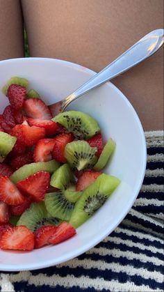 a white bowl filled with sliced kiwi and strawberries