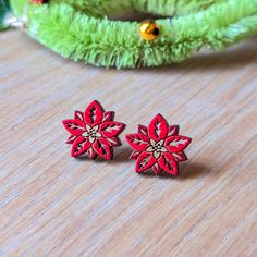 These cute poinsettia flower studs are a minimalist, yet festive statement for the Holidays and make a thoughtful gift for a fellow plant lover. Perfect for Christmas parties, plays, or New Years, these botanical earrings bring the Holiday cheer! These original earrings are hand painted on cherry wood with a vibrant palette of reds and gold. Lightweight and unique, these are not ordinary Holiday earrings. Option 1: Studs These earrings feature hypoallergenic 304 gold-finished stainless steel studs with butterfly backs.  Option 2: 20mm Hoops These earrings feature 20mm hypoallergenic 316 gold-finished surgical stainless steel hoops. The fronts are sealed with a semi-gloss varnish for protection and durability. The backs are unstained and unsealed cherry wood. Like these? Grab the matching n Poinsettia Earrings, Wood Stud Earrings, Wood Earrings Stud, Engraved Earrings, Large Statement Earrings, Botanical Earrings, Holiday Earrings, Wood Studs, Poinsettia Flower