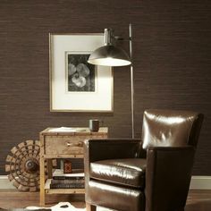 a brown chair sitting in front of a lamp next to a wooden table