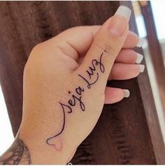 a woman's hand with a small tattoo on it