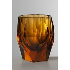 an orange glass vase sitting on top of a table