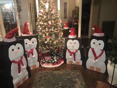 christmas decorations made to look like penguins and snowmen in front of a christmas tree