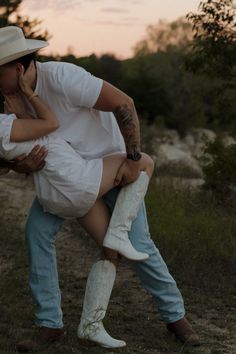 a man holding a woman in his arms while she is kissing her face with the other hand