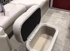 the inside of a white boat with an open seat and storage compartment on the floor