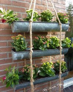 several metal planters are hanging on a brick wall