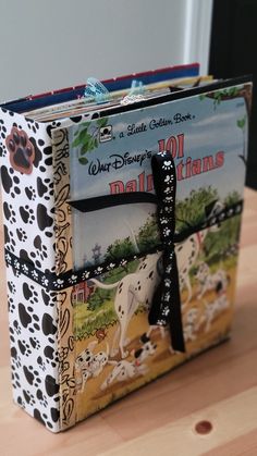 the book is decorated with black and white dogs on it's front cover, which has a bow at the top