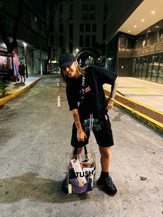 a woman with tattoos is holding a bag in the middle of an empty street at night