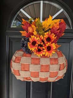 a fall wreath with sunflowers and leaves in it on the front door sill